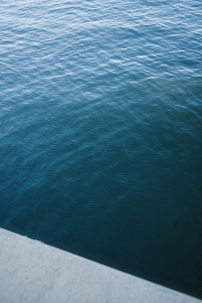 gallery-06 Peaceful blue ocean water viewed from a concrete edge, ideal for backgrounds or texture.