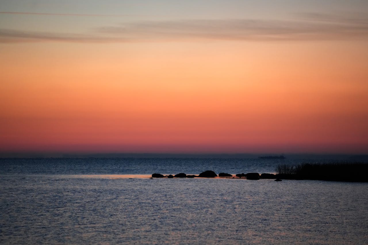 gallery-03 A tranquil sunset view over the ocean with a soft gradient sky and calm waters.