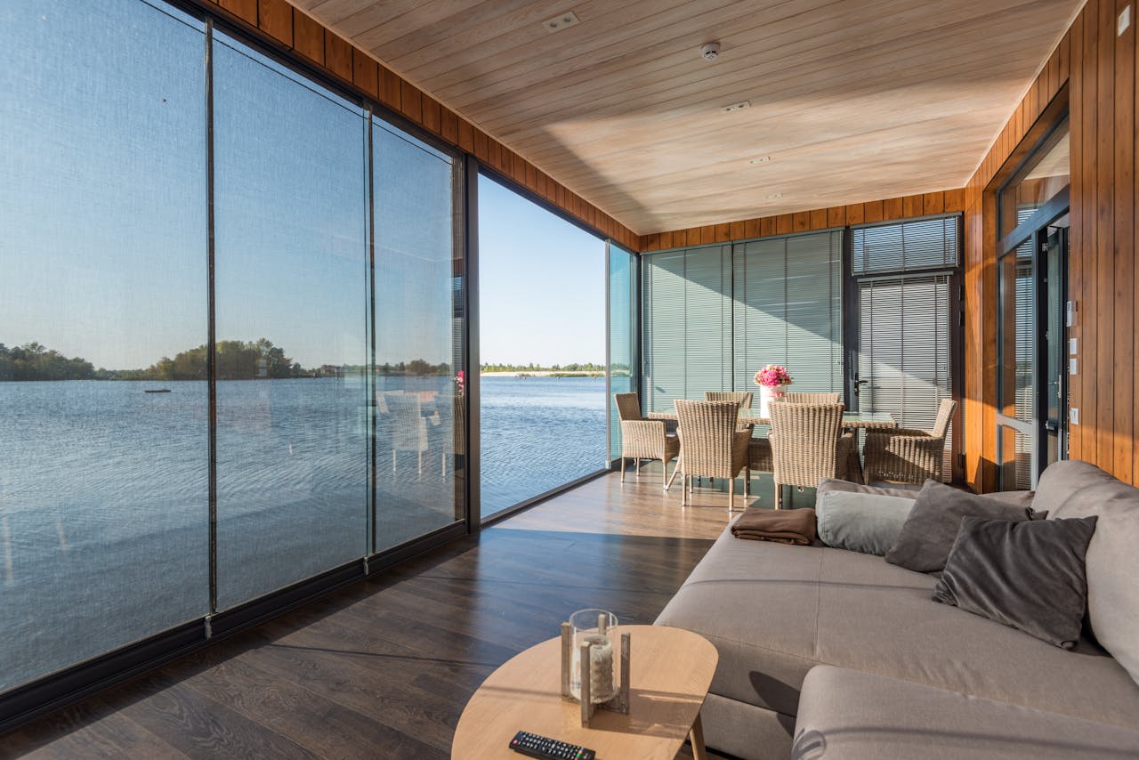 gallery-04 Luxurious living room with glass walls offering serene water views.